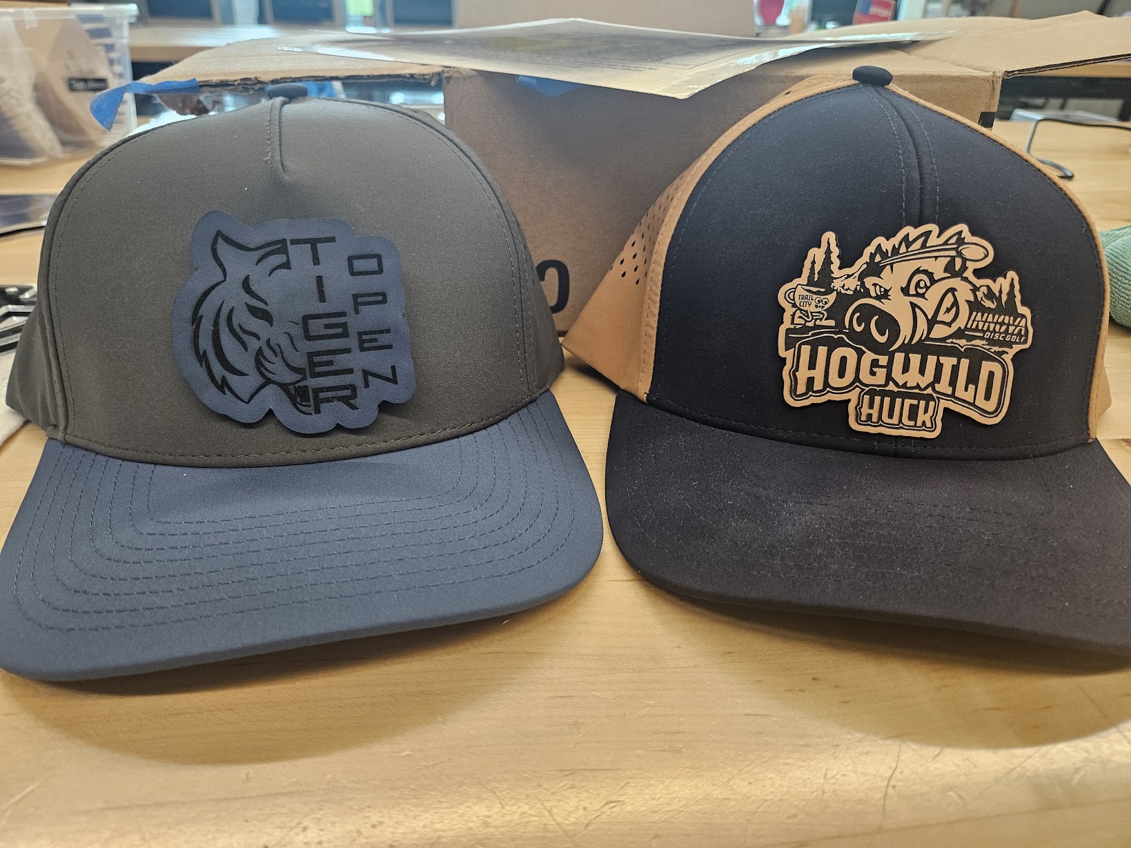Two performance hats with custom laser-cut leatherette patches